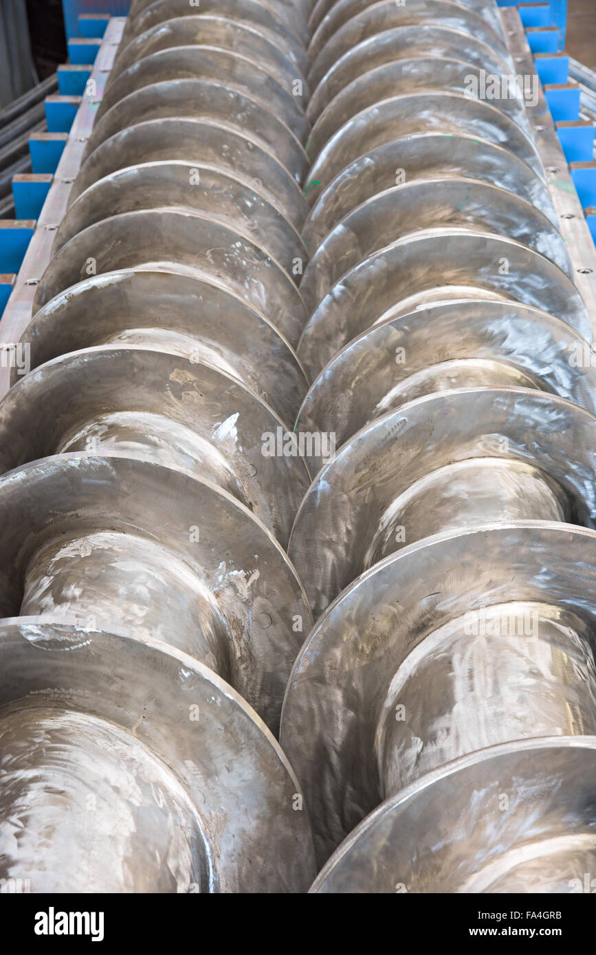Industrial twin screw press for processing of waste from meat production, with the covers open. Shallow depth of field. Stock Photo