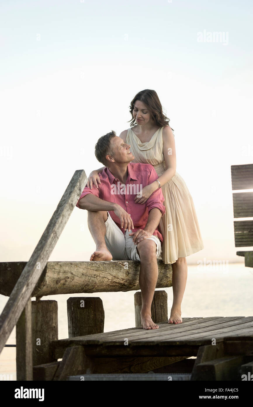 Mature couple looking at each other and smiling on pier, Bavaria, Germany Stock Photo