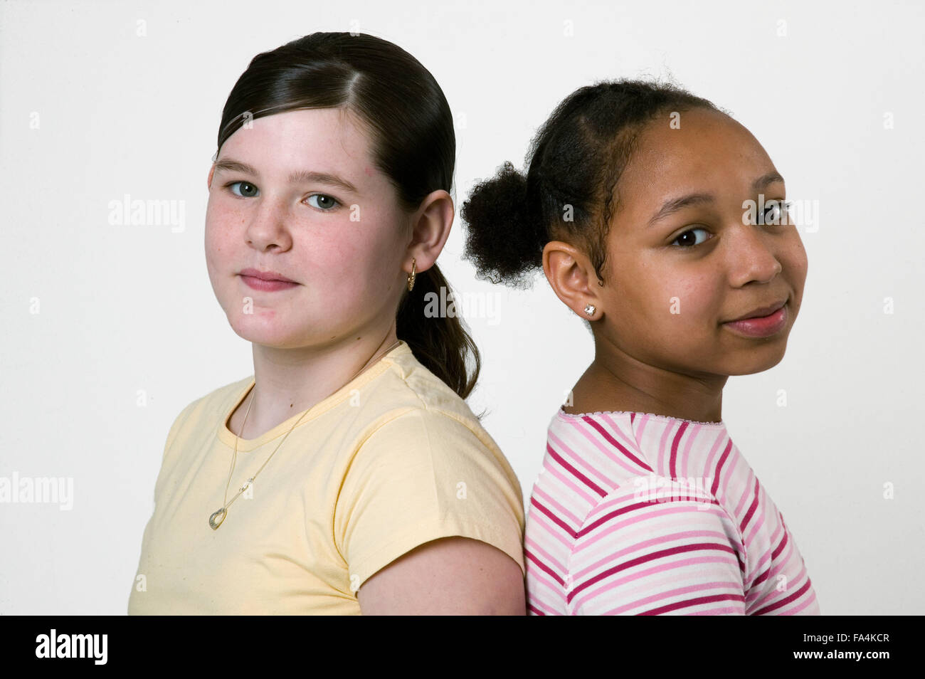 Two friends standing back to back; laughing Stock Photo - Alamy
