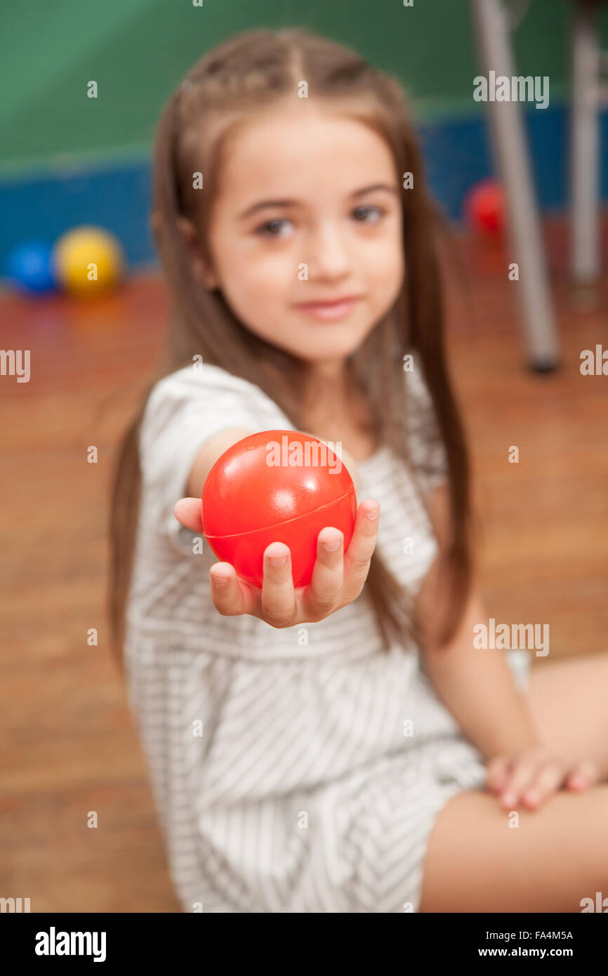 Girl showing a red ball Stock Photo