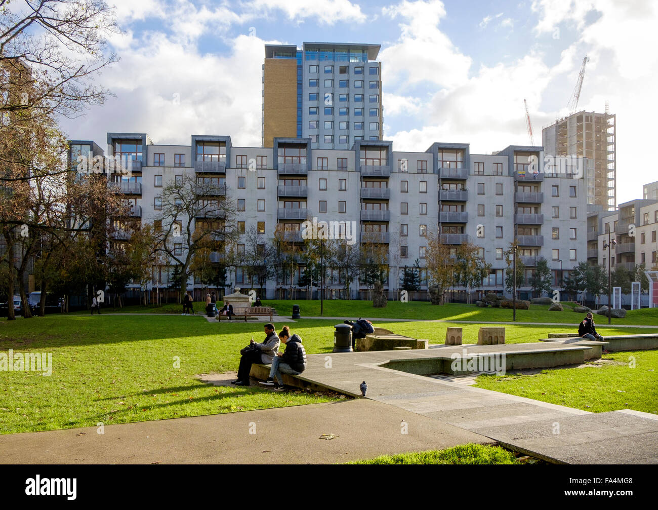 On the Whitechapel Road at Aldgate, people sit having lunch in Altab Ali Park. Stock Photo