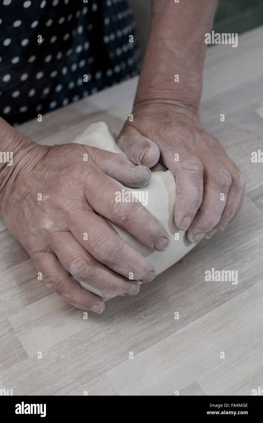 Closeup of female potter kneading clay on workbench, Bavaria, Germany