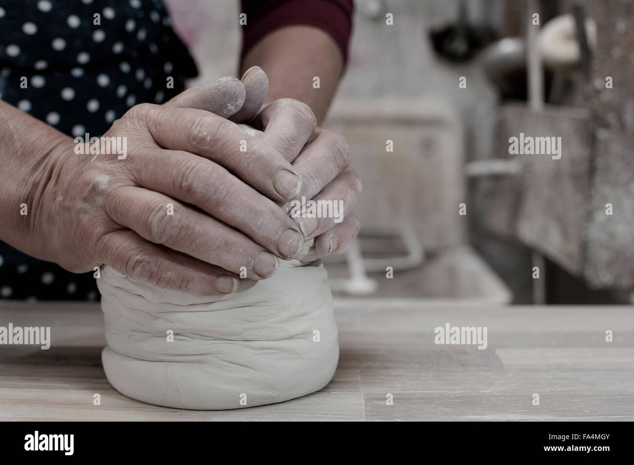 Closeup of female potter kneading clay on workbench, Bavaria, Germany