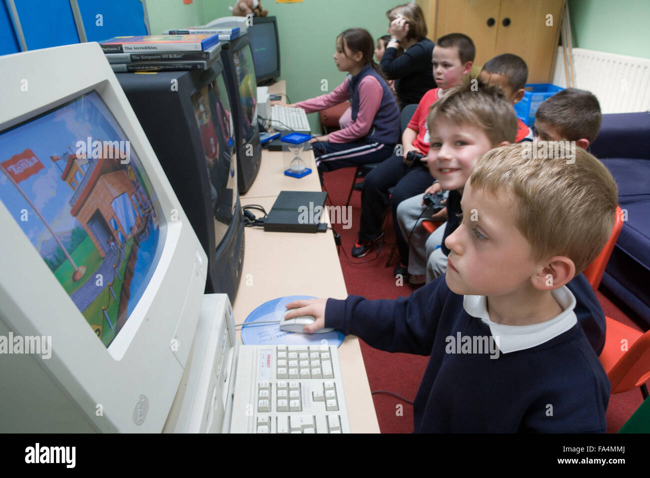 Group of primary school children using computers in classroom Stock