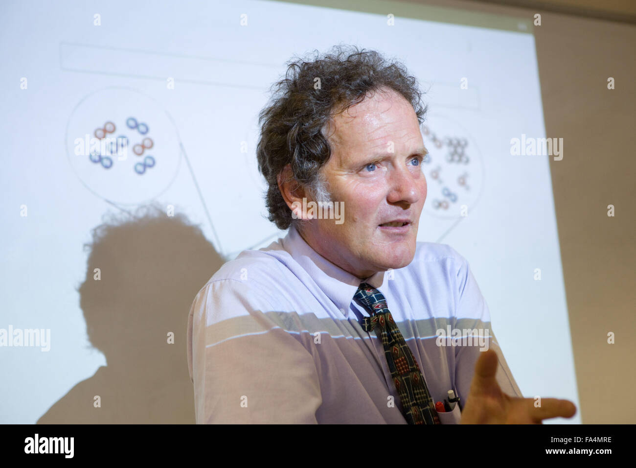 Secondary School teacher standing in front of a whiteboard explaining the background to car combustion and air quality Stock Photo