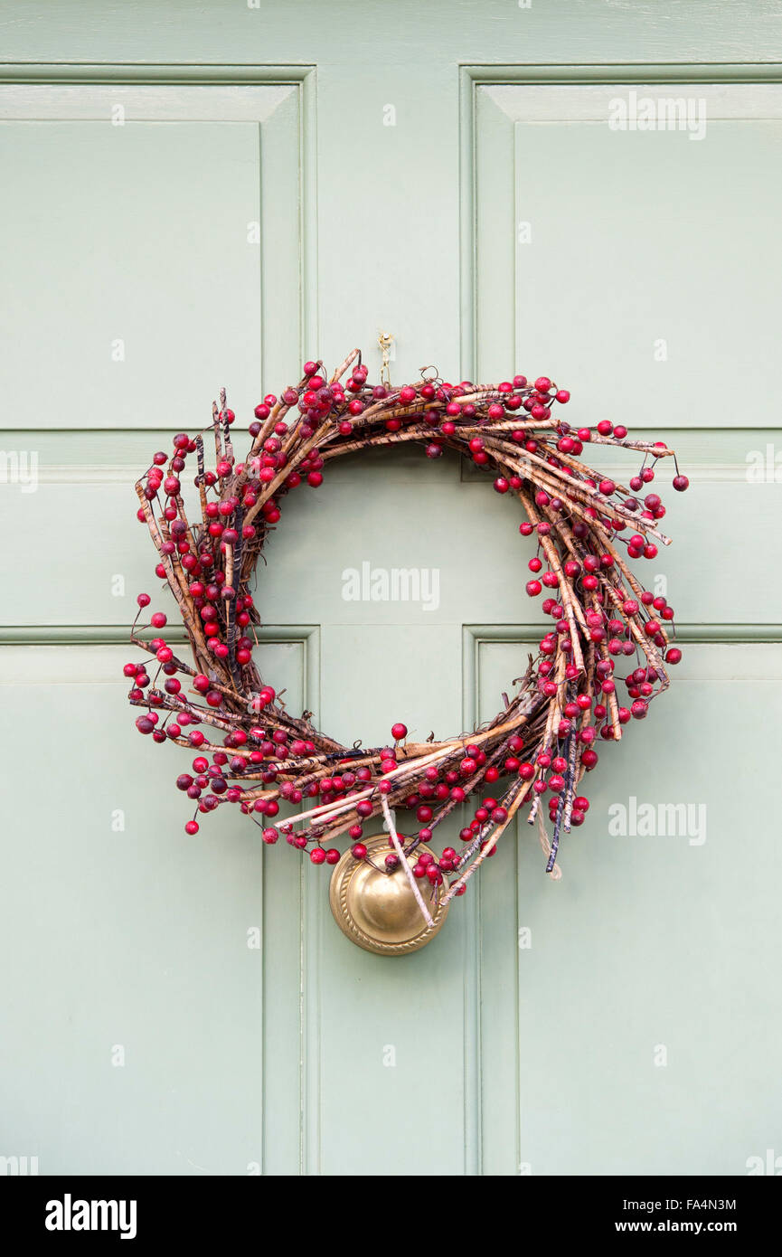 Christmasd red berry wreath on a wooden door Stock Photo