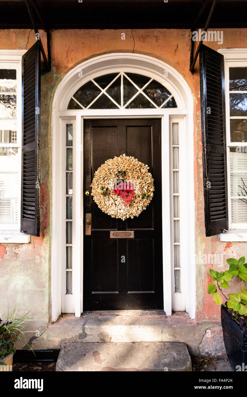 Door on a traditional home along Church Street decorated with a christmas wreath for the holiday season in Charleston, SC. Stock Photo