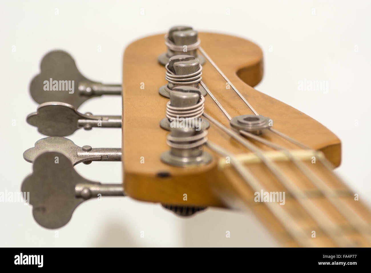 the head of a four strings electric bass with its prockets, string guide, palette and tuners Stock Photo