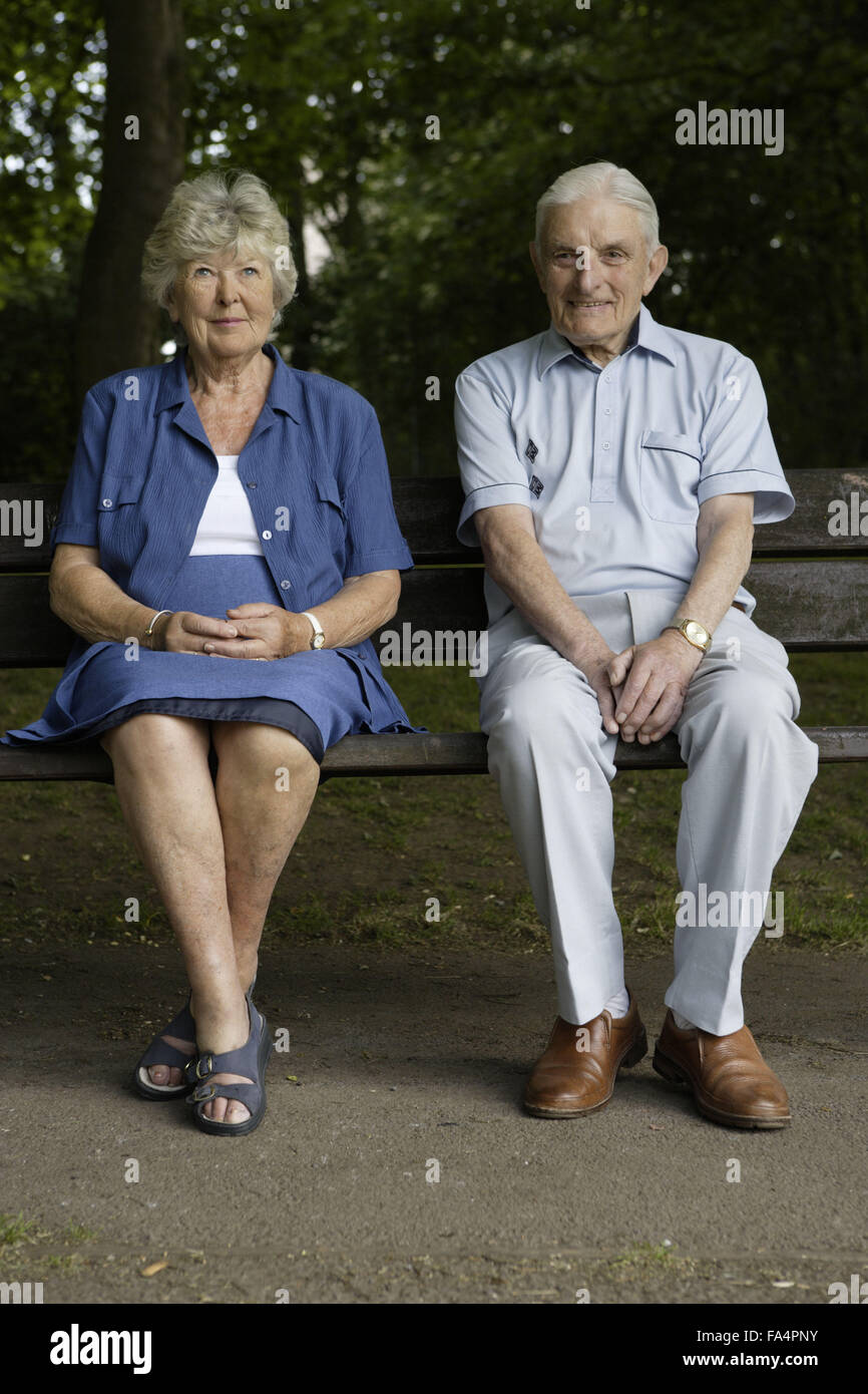 Older couple sitting on a bench in the park and looking at the view ...
