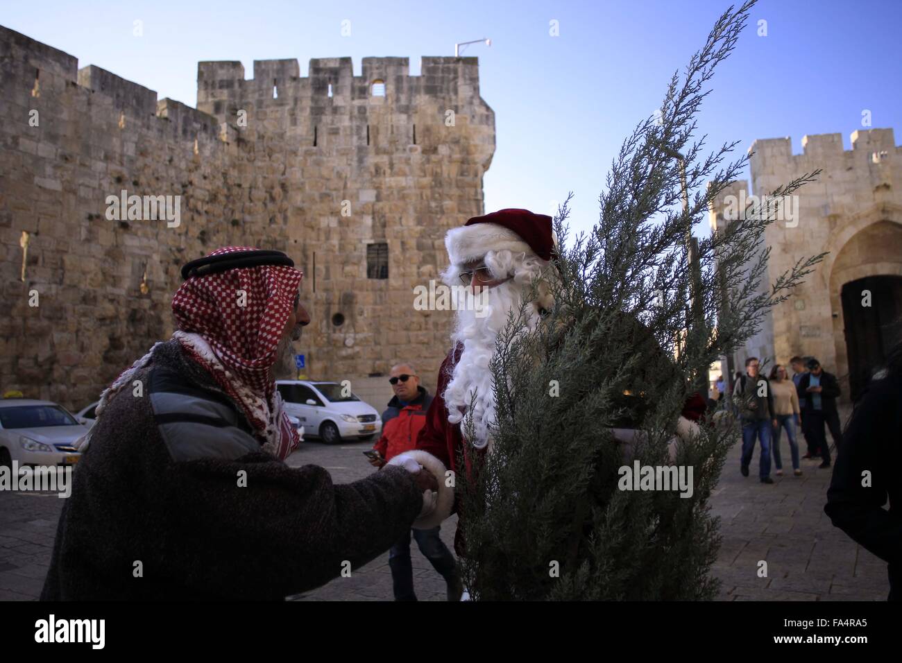 Jerusalem. 21st Dec, 2015. Israeli-Arab Issa Kassissieh wears a Santa Claus costume as he holds a bell and a Christmas tree during an annual Christmas tree distribution activity by the Jerusalem municipality, on Dec. 21, 2015. Credit:  Muammar Awad/Xinhua/Alamy Live News Stock Photo