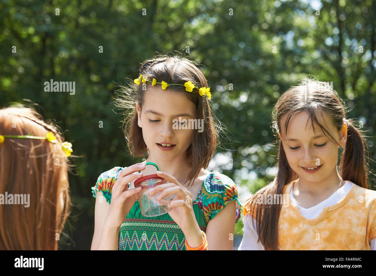 Girls examining a spider in container, Munich, Bavaria, Germany Stock Photo