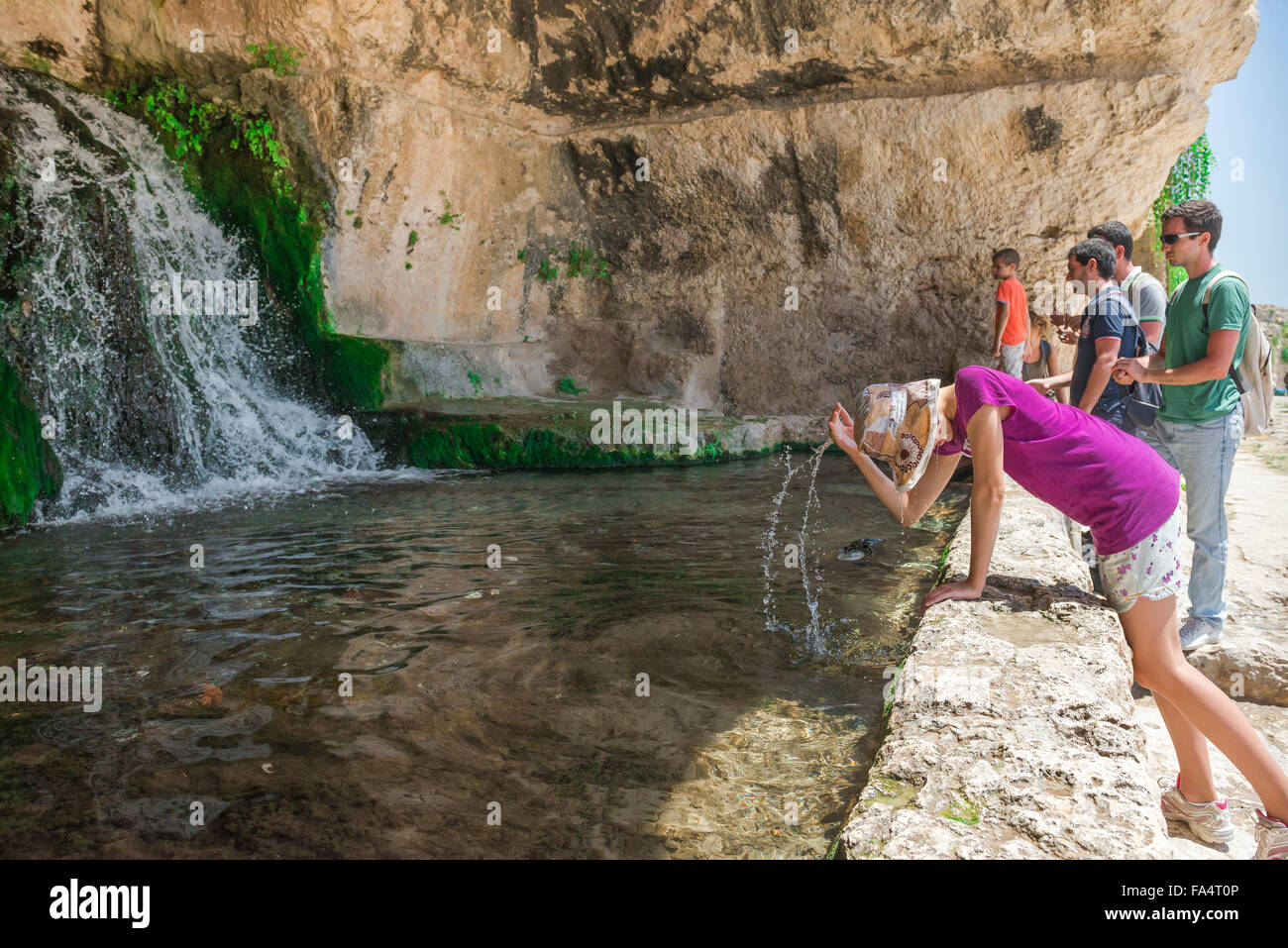 Syracuse Sicily, young tourists cool off in the Nymph's Grotto (Grotta del ninfeo) in the Archaeological Park in Syracuse, Siracusa, Sicily Stock Photo