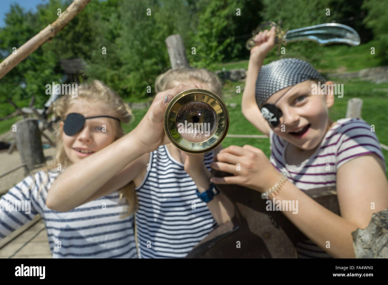 Three girls playing on a pirate ship in adventure playground, Bavaria, Germany Stock Photo