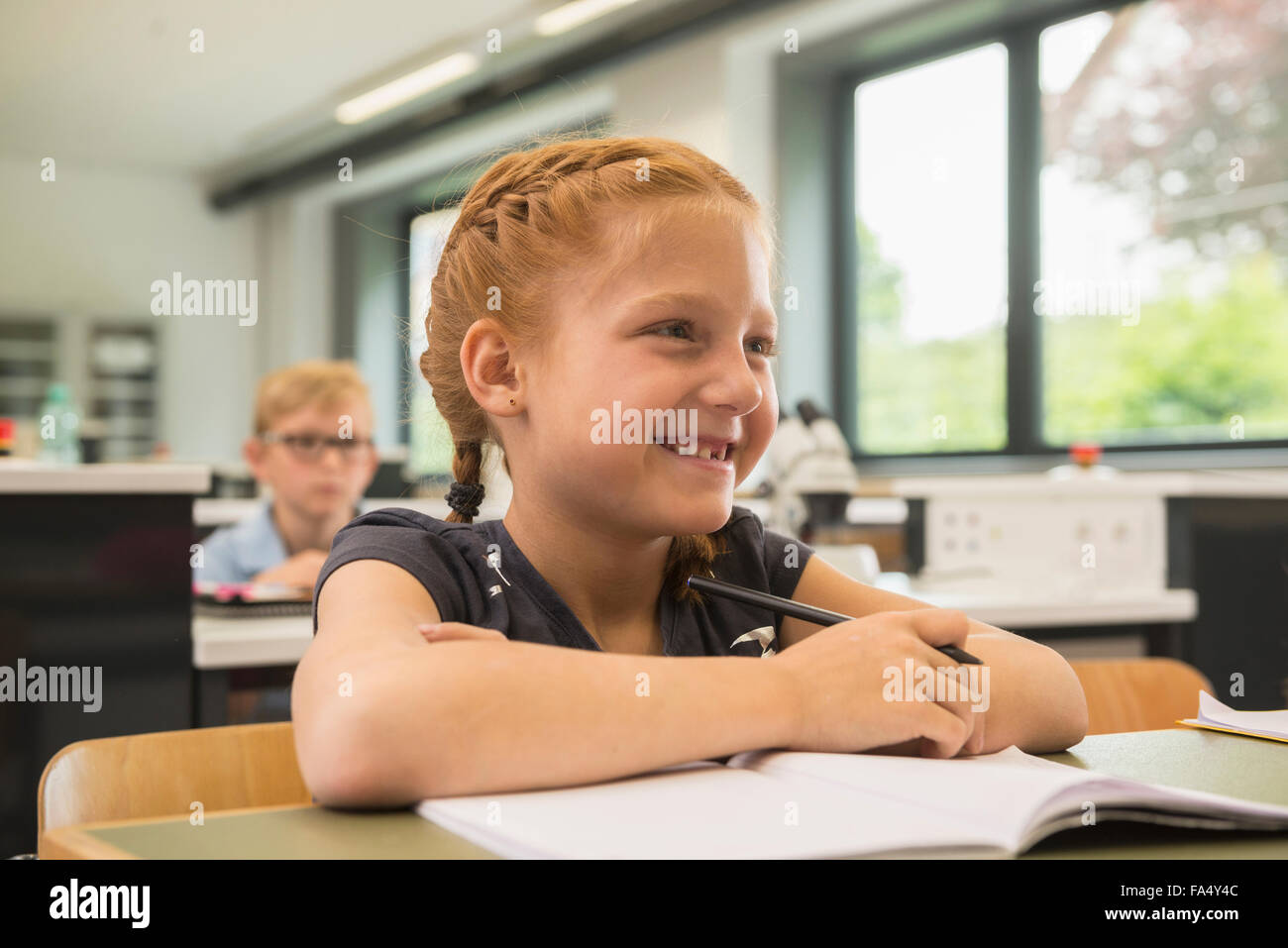 schoolgirl smiling in classroom, Fürstenfeldbruck, Bavaria, Germany Stock Photo