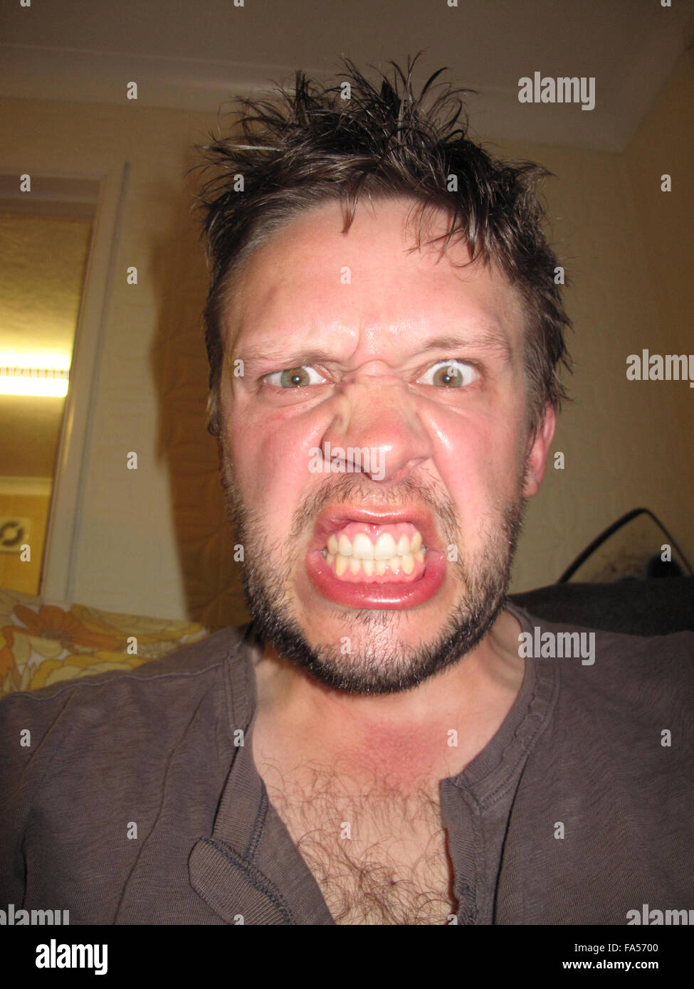 An angry face of a man bearing his teeth Stock Photo