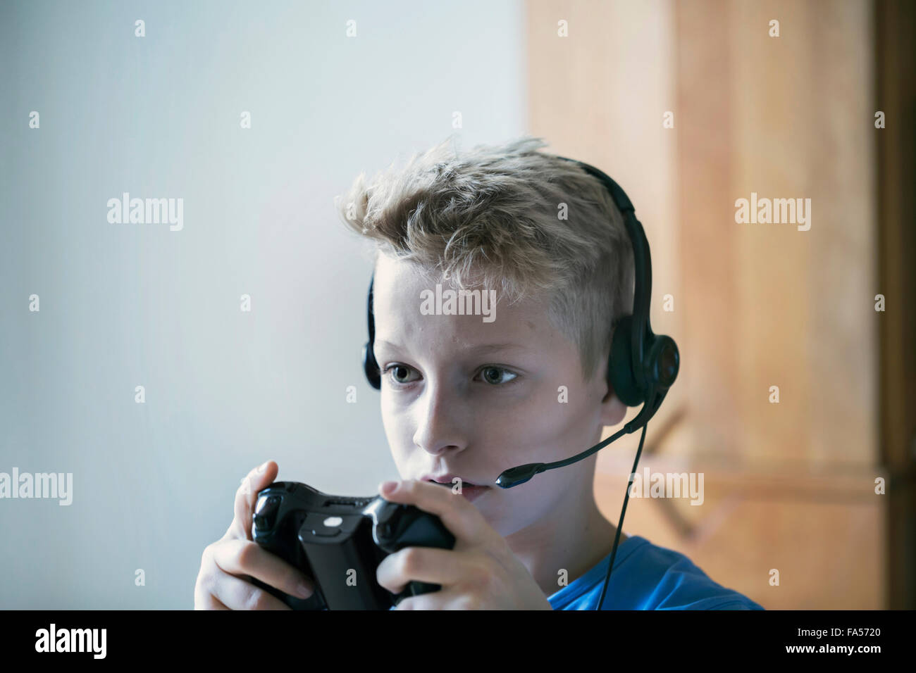 Boy wearing headset and playing video game, Freiburg im Breisgau, Baden