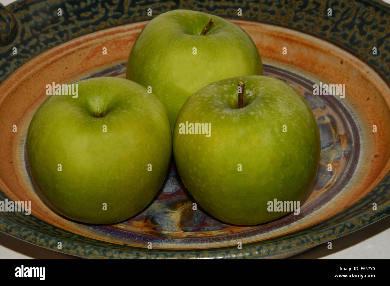Three Granny Smith Apples on Ceramic plate Stock Photo Alamy