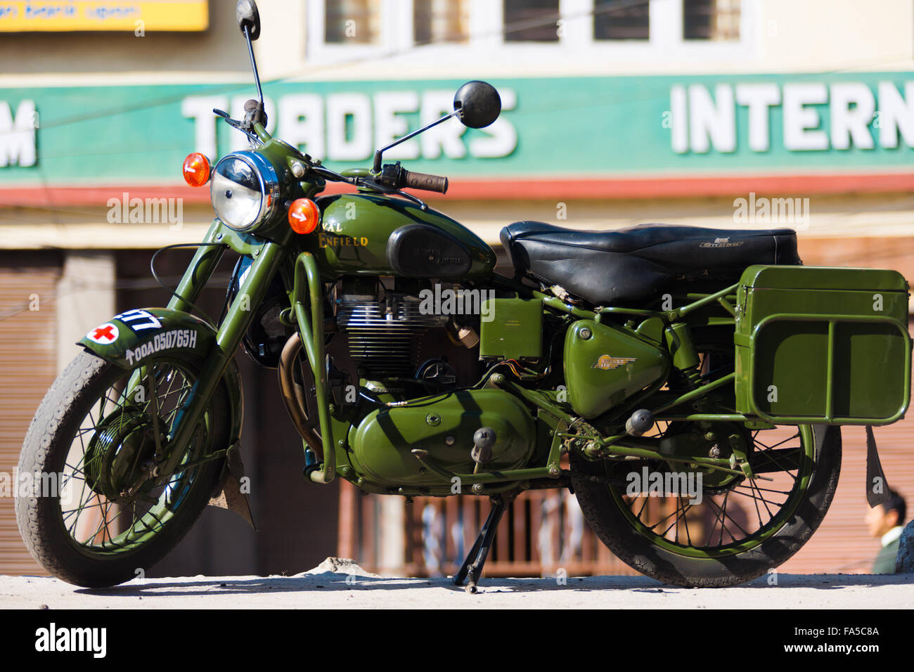 A green Enfield Bullet 350, a cult classic British motorcycle brand, is parked on a Gangtok street Stock Photo