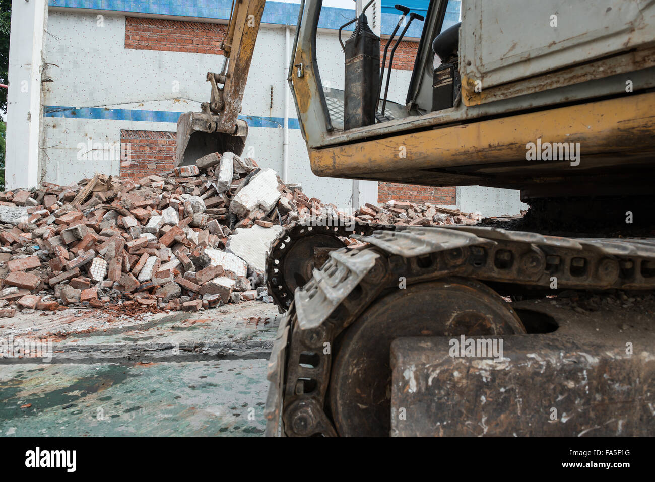 excavator demolishing concrete and brick rubble debris horizontal Stock Photo