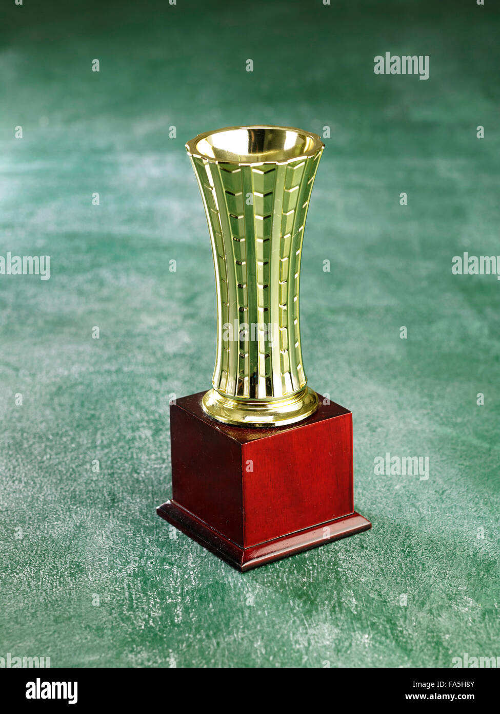 golden trophy on the green background Stock Photo - Alamy