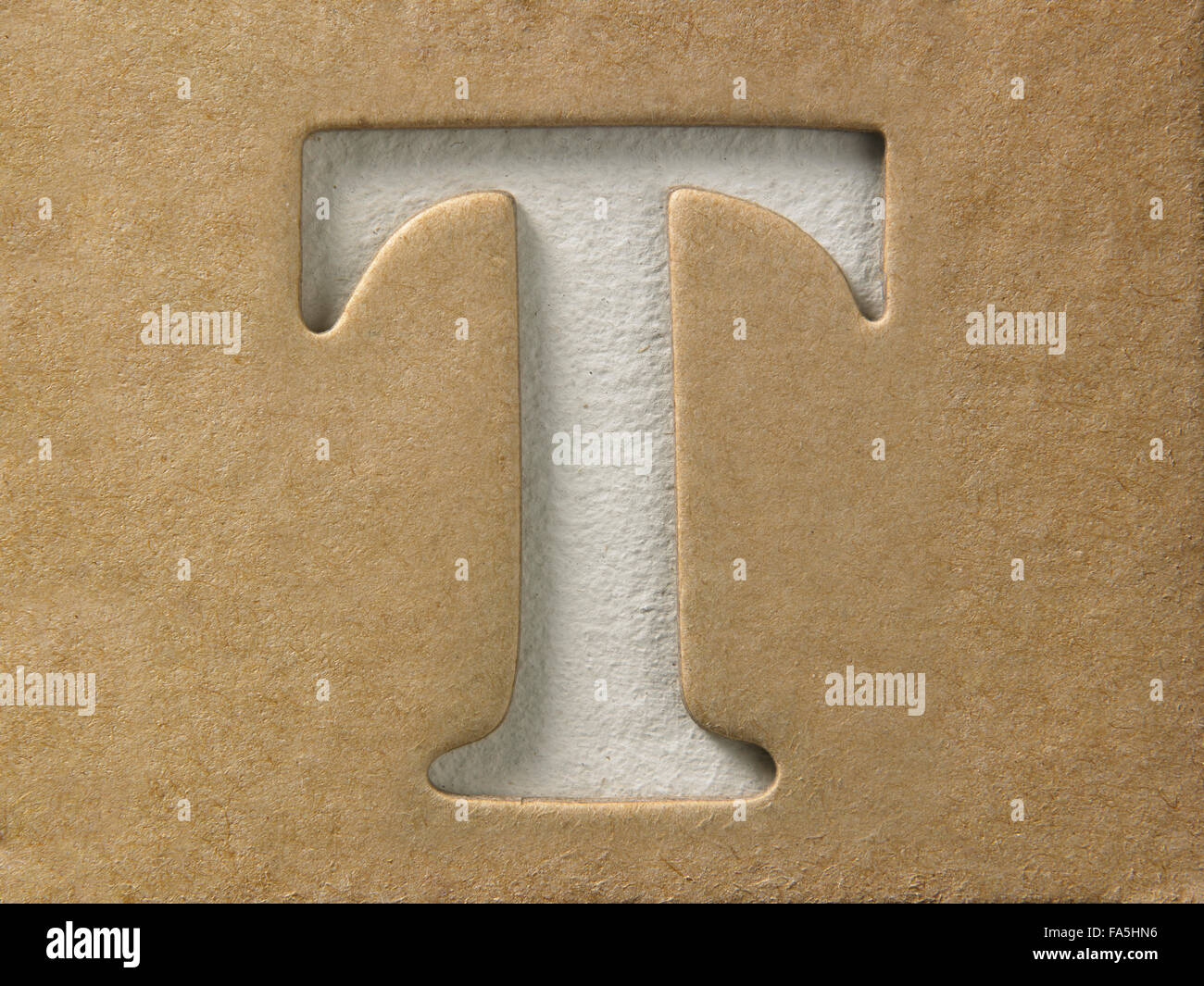 cut out alphabet t on the brown cardboard Stock Photo