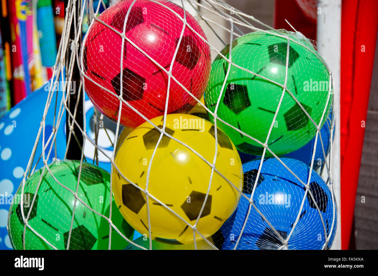 Multicolored plastic pseudo football balls in net back on sale outdoors
