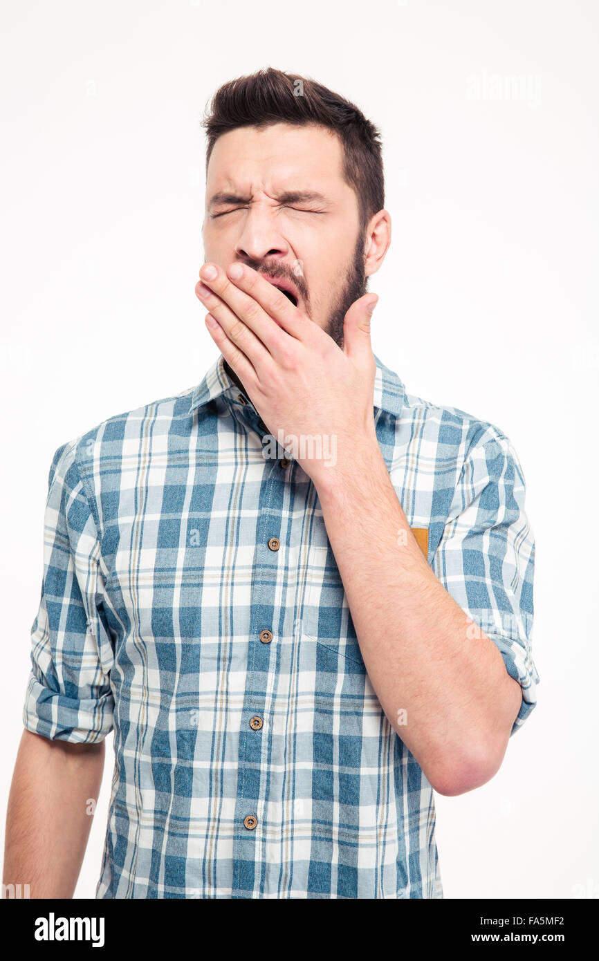 Tired exhausted bearded young man in checkered shirt standing and