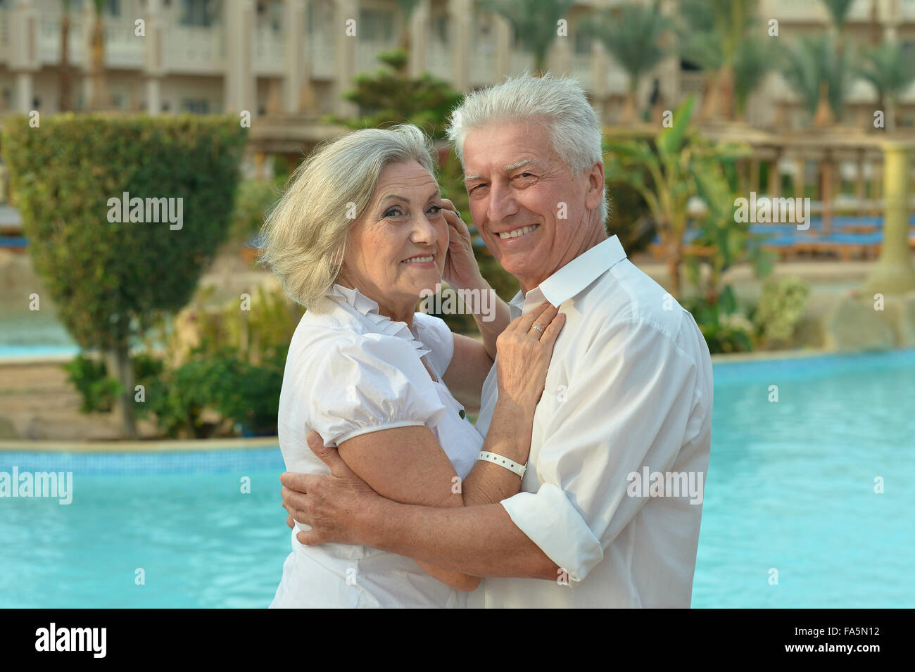 Senior couple relaxing near pool Stock Photo - Alamy