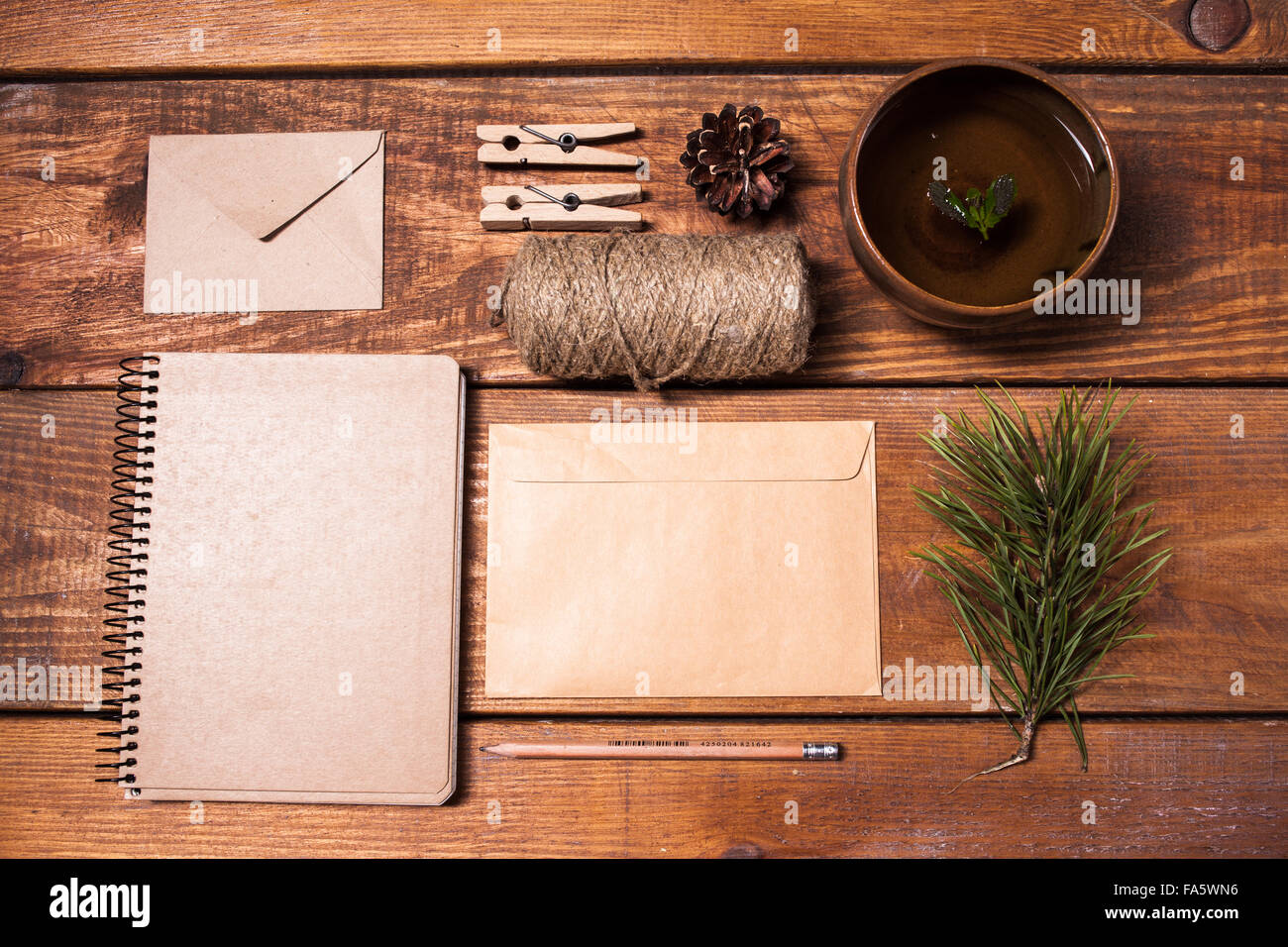 Notebook for recipes, paper envelopess, rope and clothespins on wooden table. Stock Photo