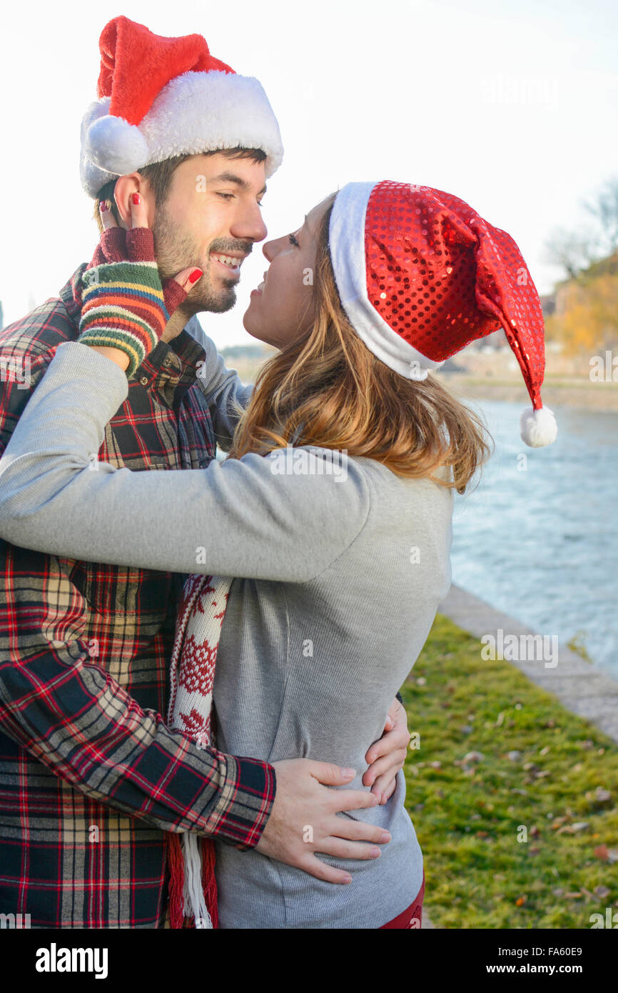 Couple in love kissing outdoors with Christmas hats Stock Photo
