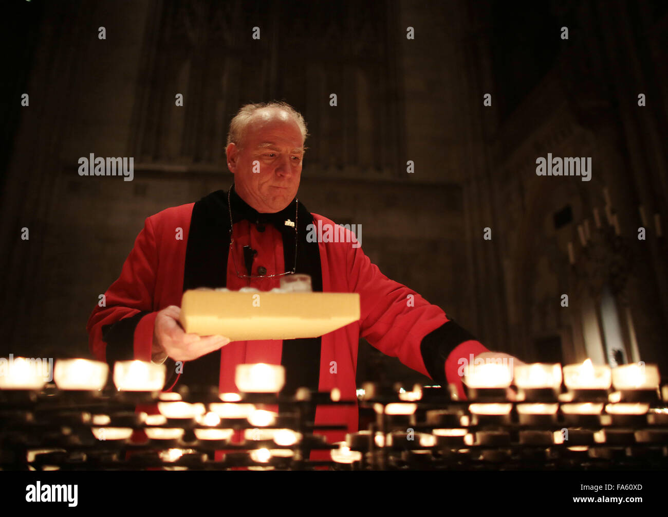 Supervisory staffer Franz-Jochem Henk gathers the candles in the cathedral in Cologne, Germany, late 07 December 2015. Photo: OLIVER BERG/dpa Stock Photo