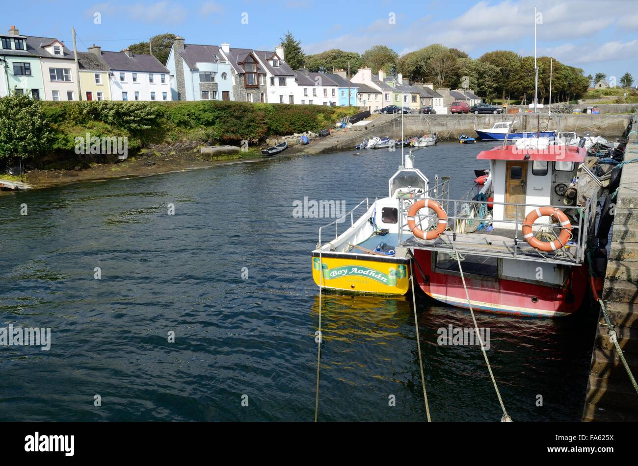 Fishing boats tied to the jetty Roundstone harbour Connemara County Galway Ireland Stock Photo