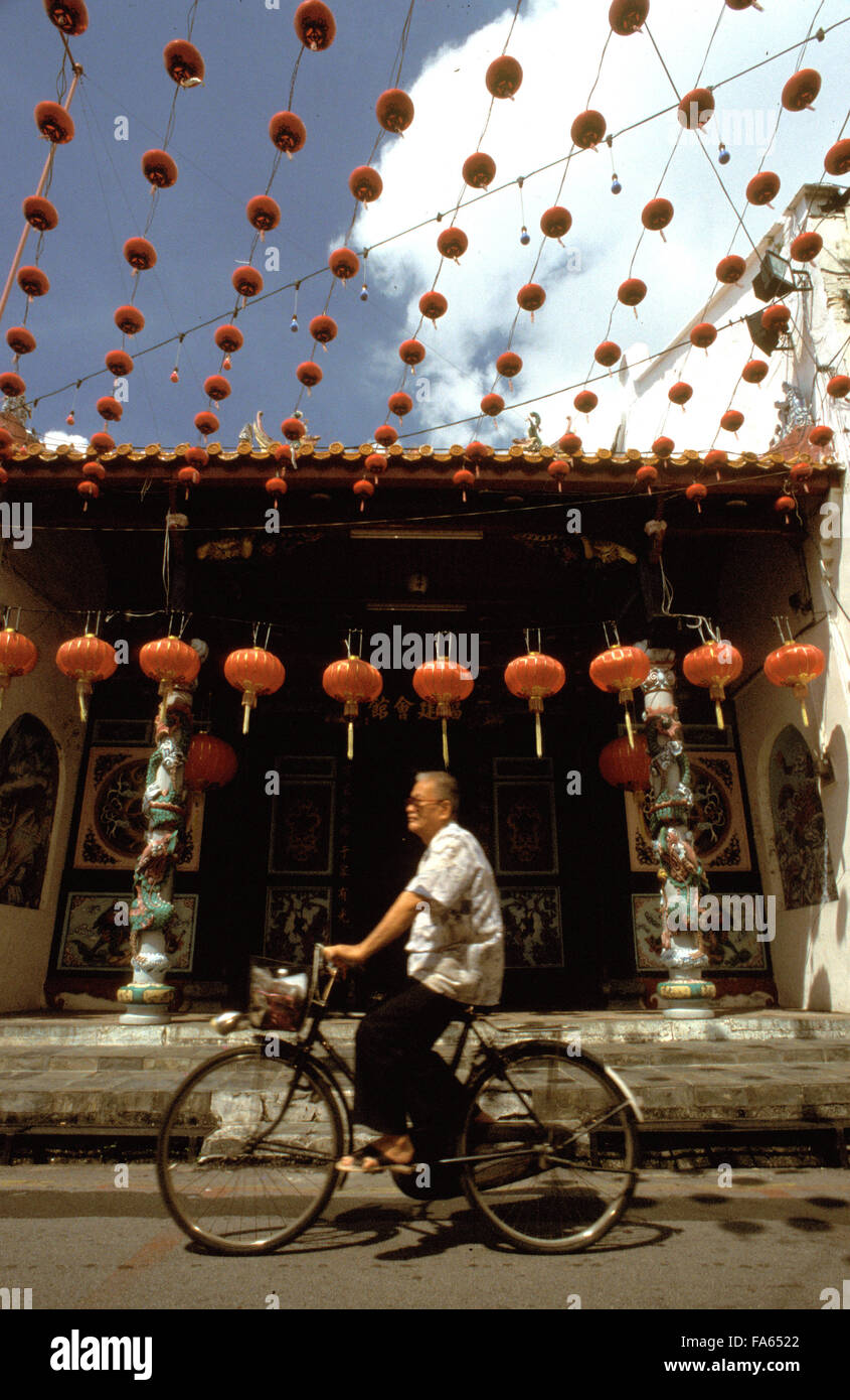 Man riding a bicycle in Chinatown of Melaka. Streets with red lanterns in the Chinatown district of Kampung Bakar Batu, Malacca or Melaka, Malaysia Stock Photo