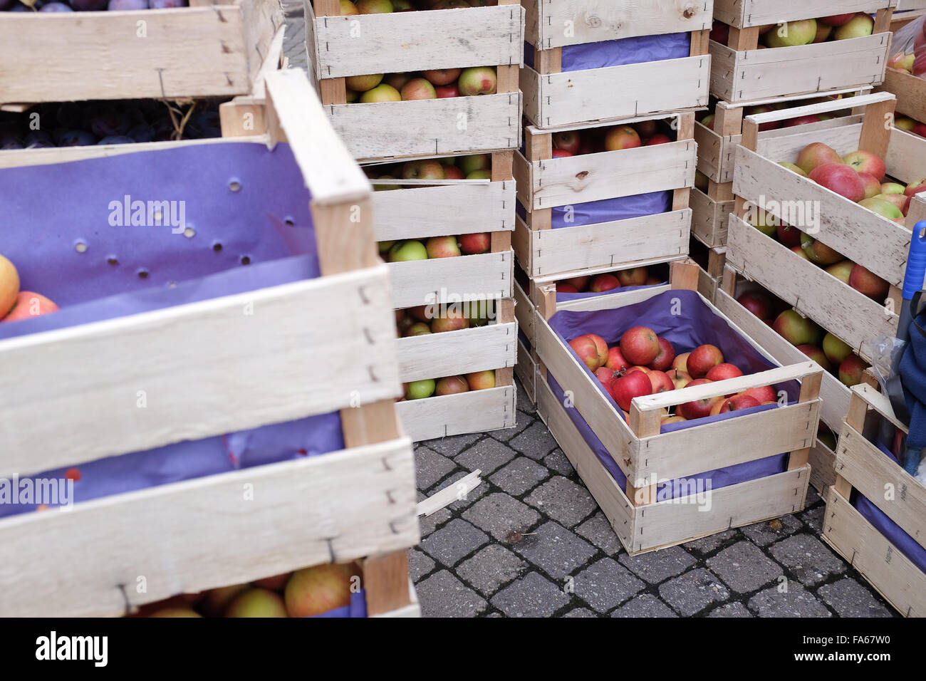 Crates of apples stacked in market Stock Photo