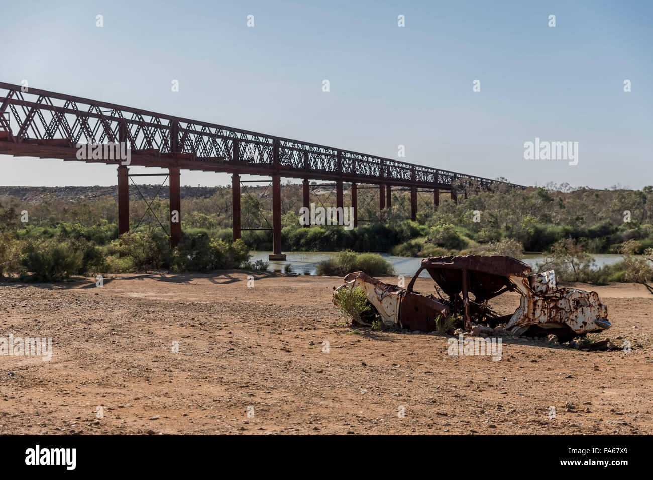 Old bridge with a car wreck in the foreground Stock Photo
