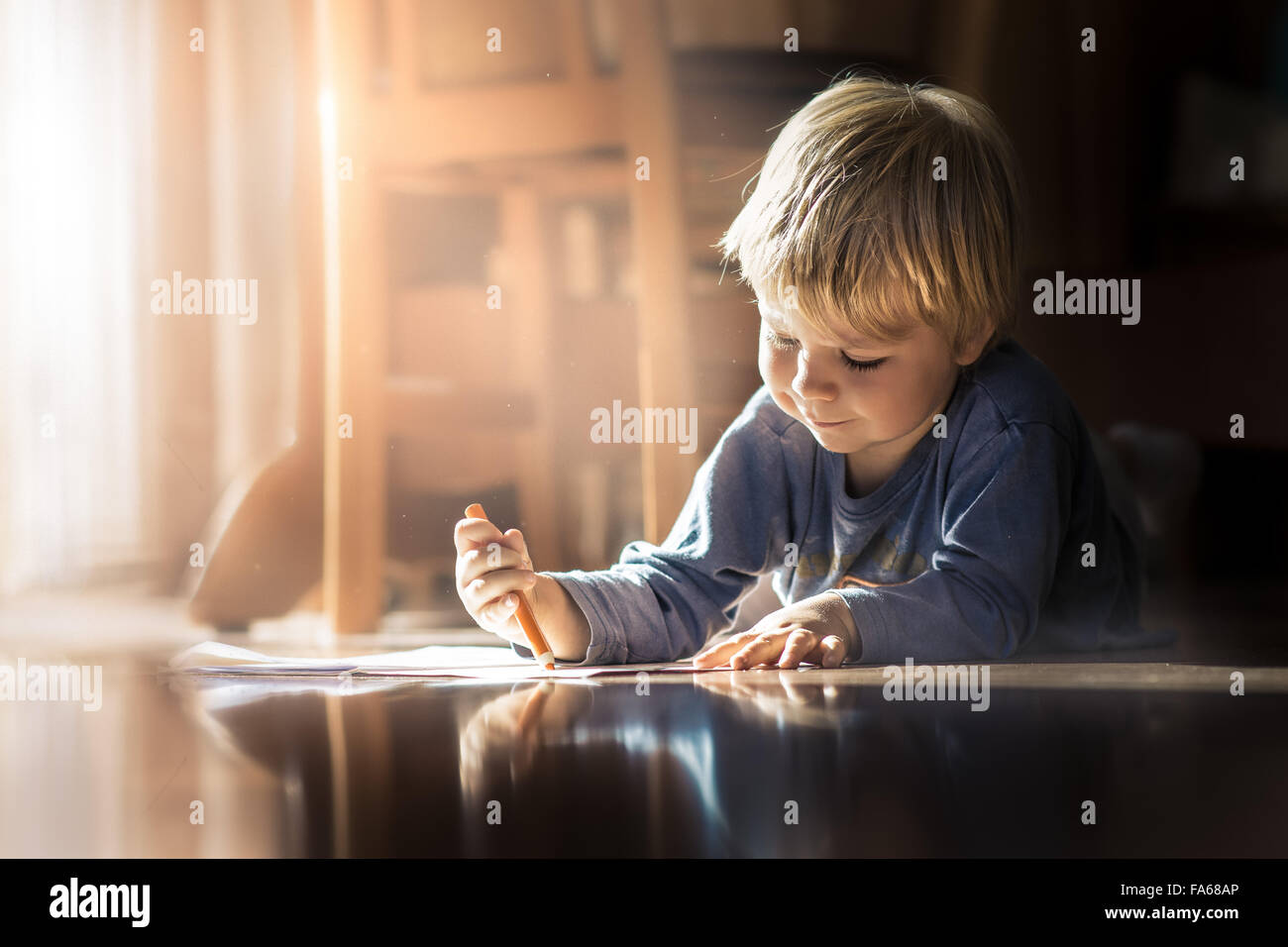 Boy lying on the floor with a coloring book Stock Photo