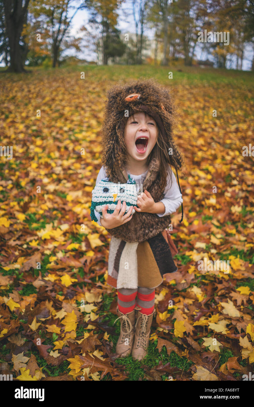 Young girl dressed as owl with owl toy shouting Stock Photo