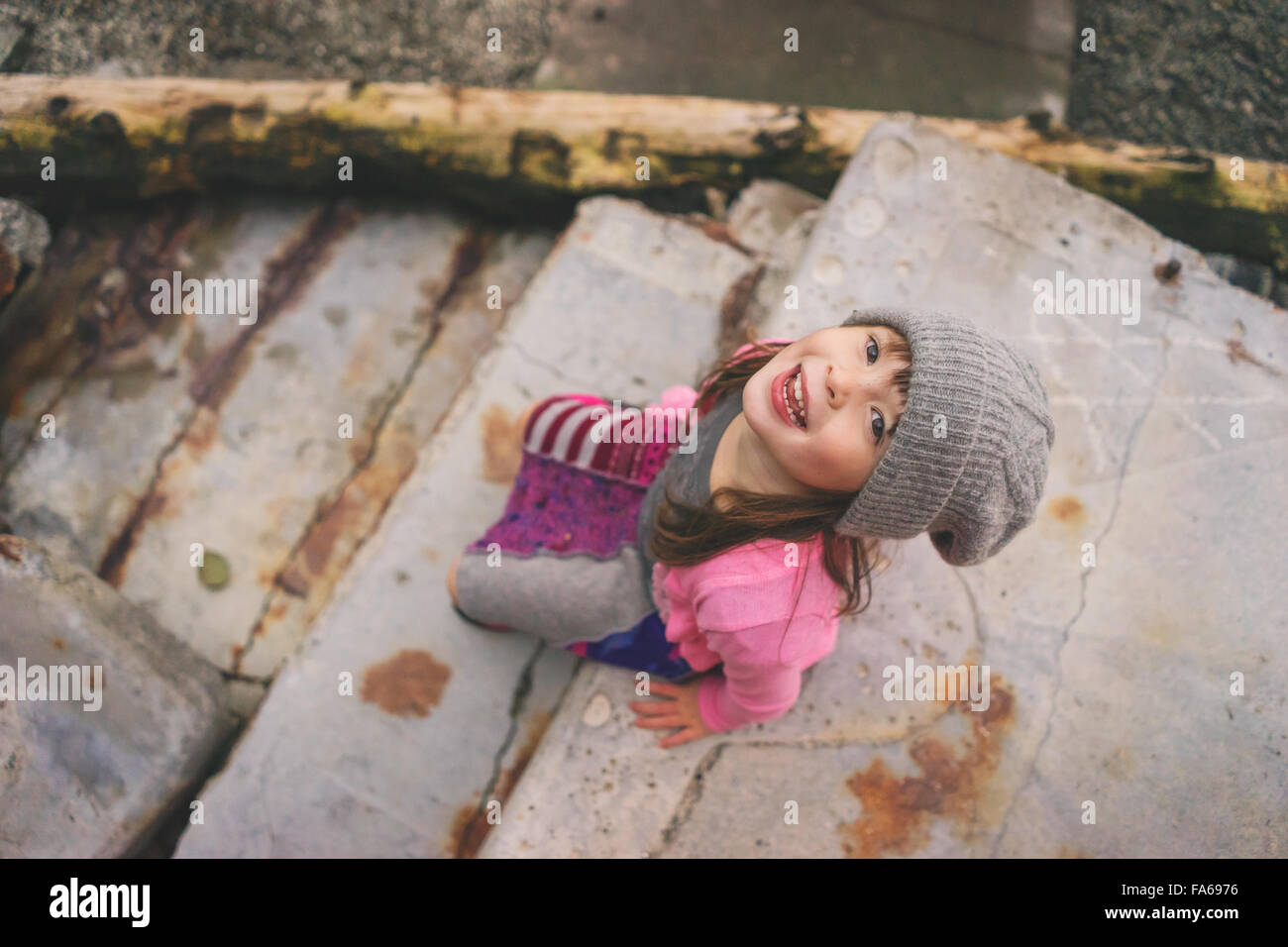 Elevated view of girl sitting on step wearing hat Stock Photo