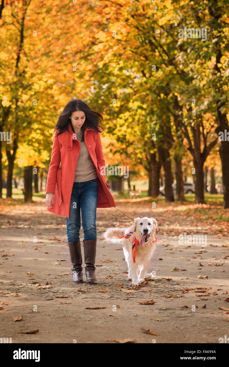 Woman walking her dog in the park Stock Photo