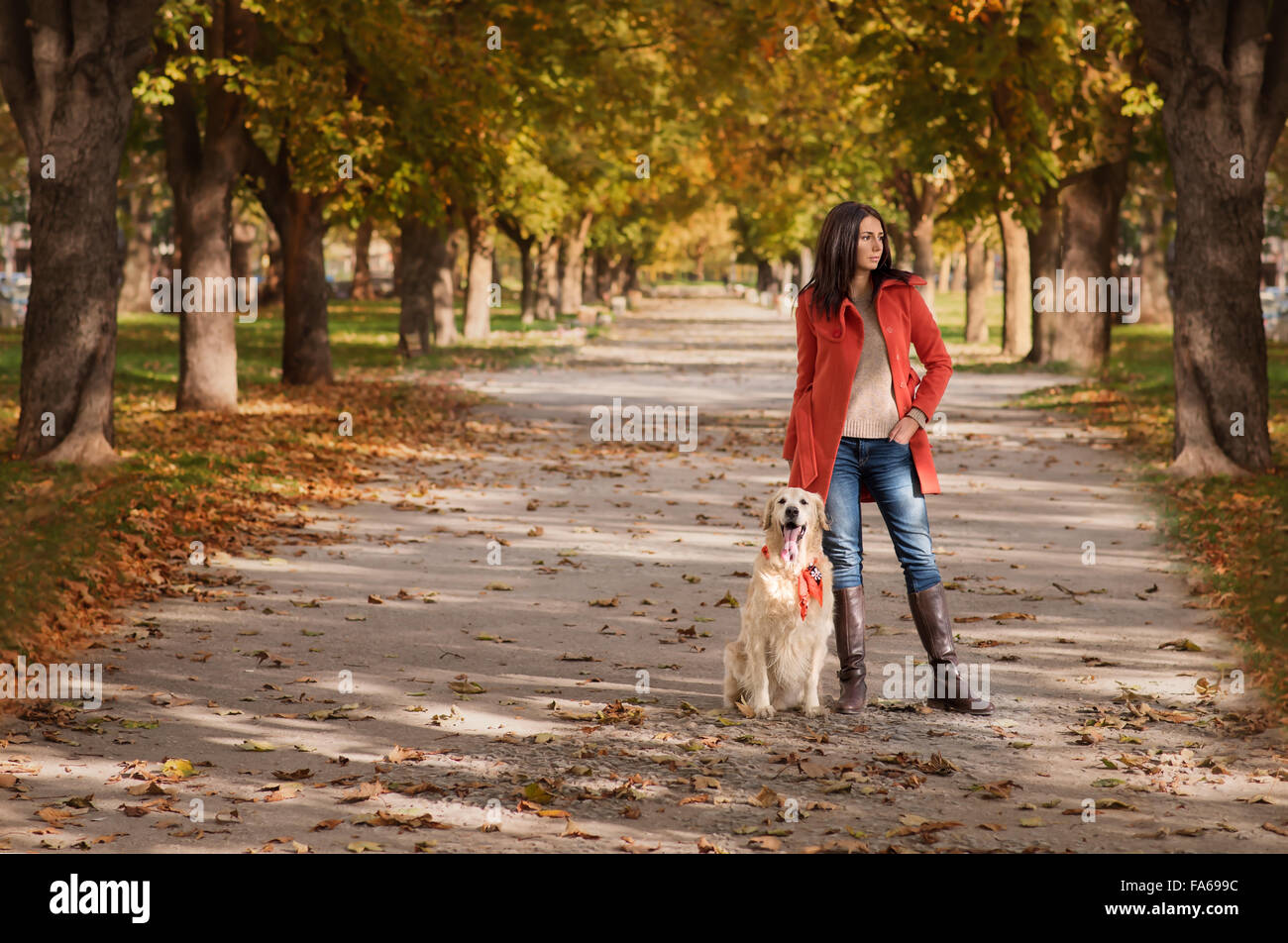 Woman standing in park with her dog Stock Photo