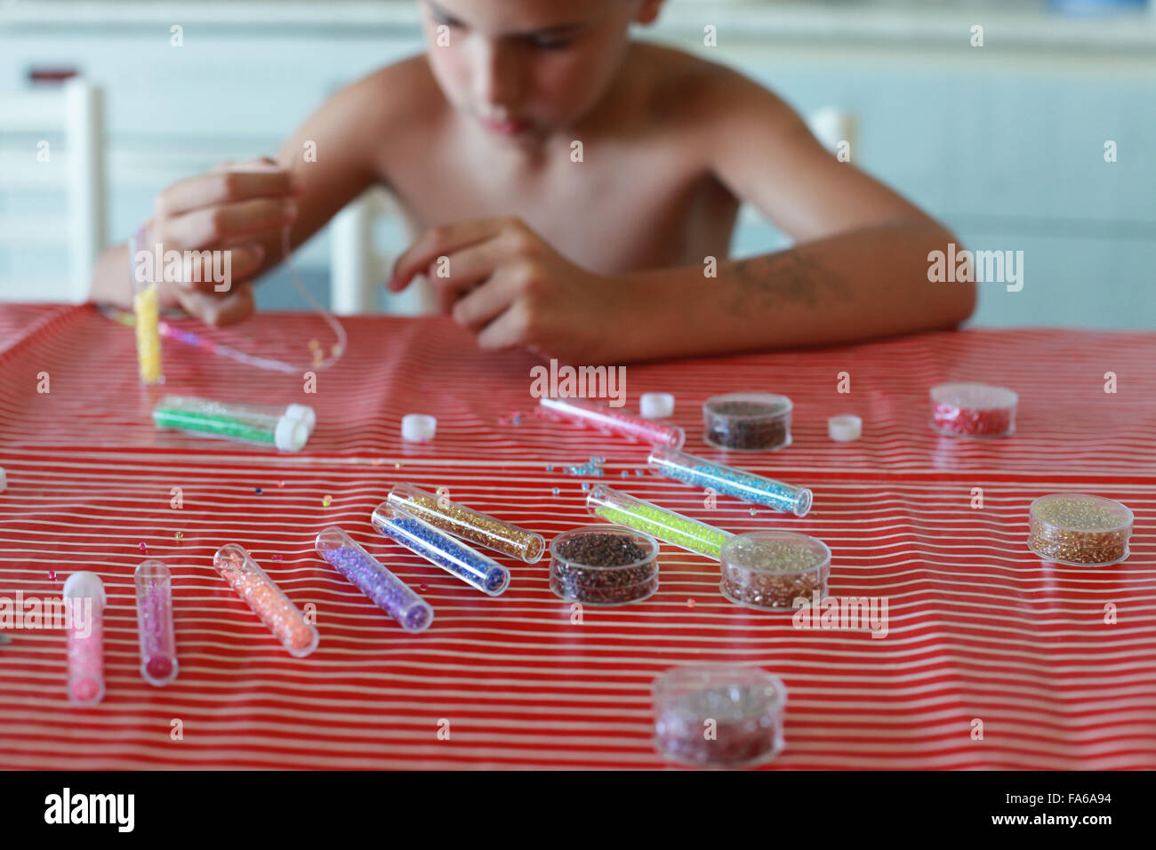 Boy making a bead necklace Stock Photo Alamy