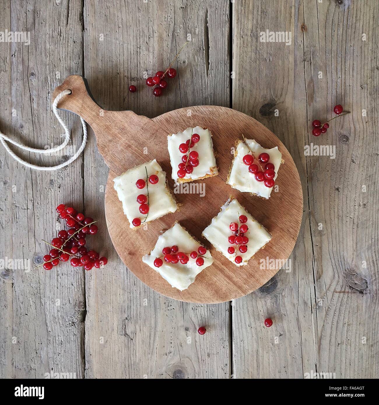 Overhead view of carrot cake with redcurrants on a chopping board Stock Photo