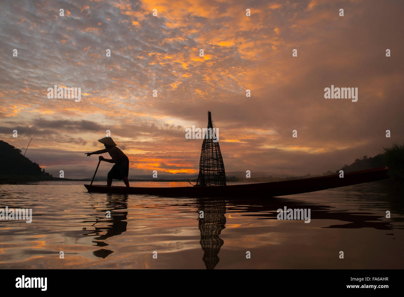 Silhouette of a man fishing in lake, Thailand Stock Photo