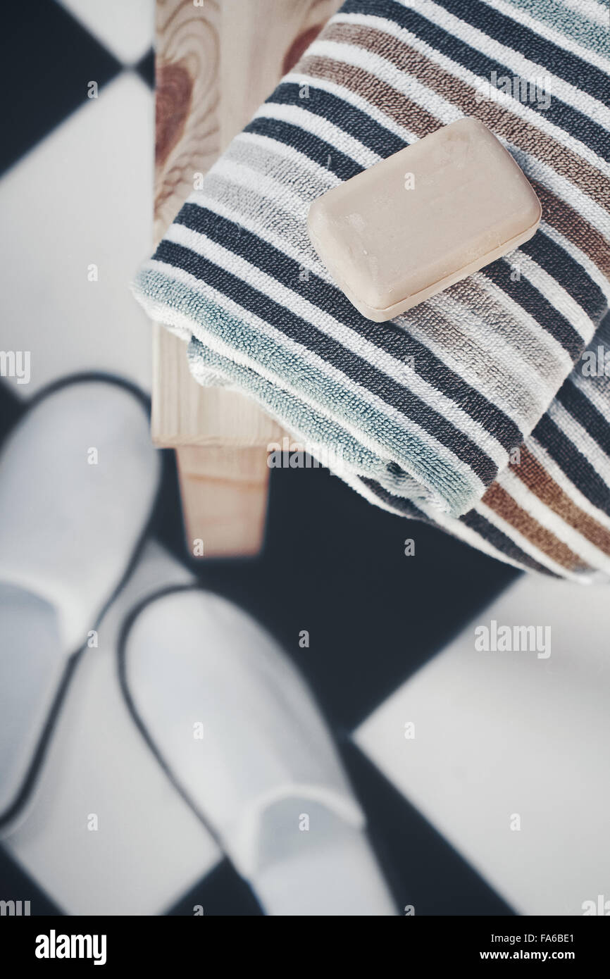 Soap, towels and slippers in a bathroom Stock Photo