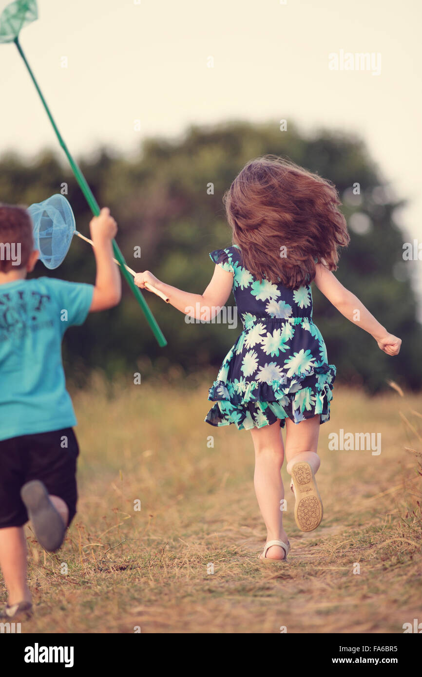 Boy and girl chasing butterflies, Sinemorets, Burgas, Bulgaria Stock Photo