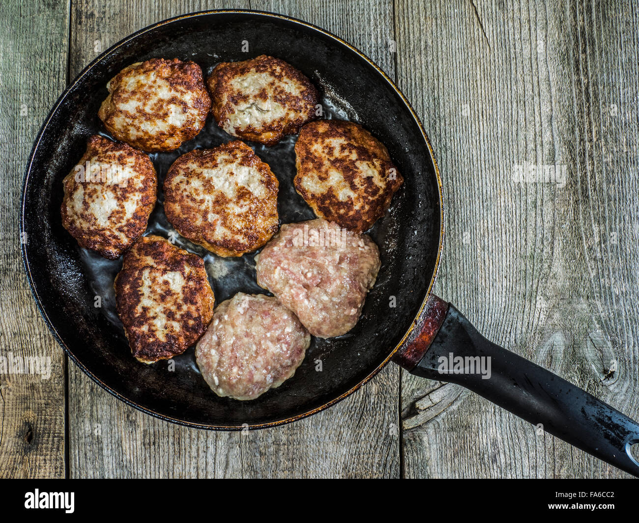 Overhead view of meat patties on a frying pan Stock Photo