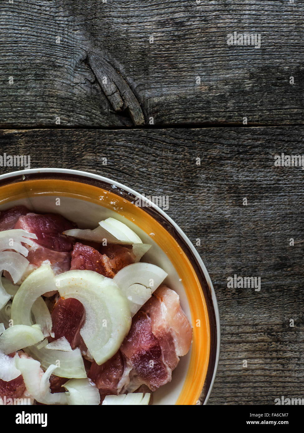 Overhead shot of raw pork and onion in a bowl Stock Photo