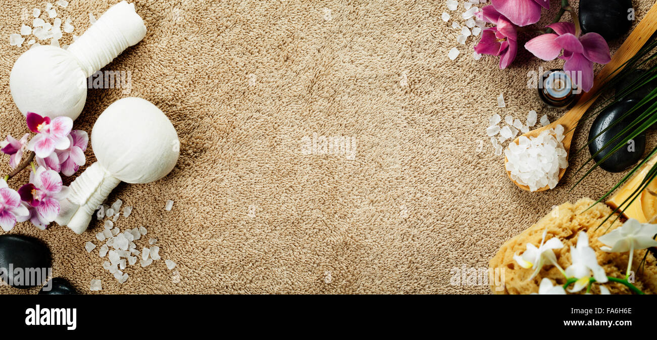 Spa background (pink orchid, herbal compress stamps, sea salt, towel and massage stones) Stock Photo