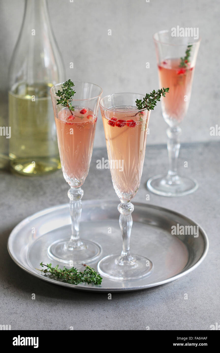 Pomegranate champagne in glasses with fresh thyme decoration Stock Photo