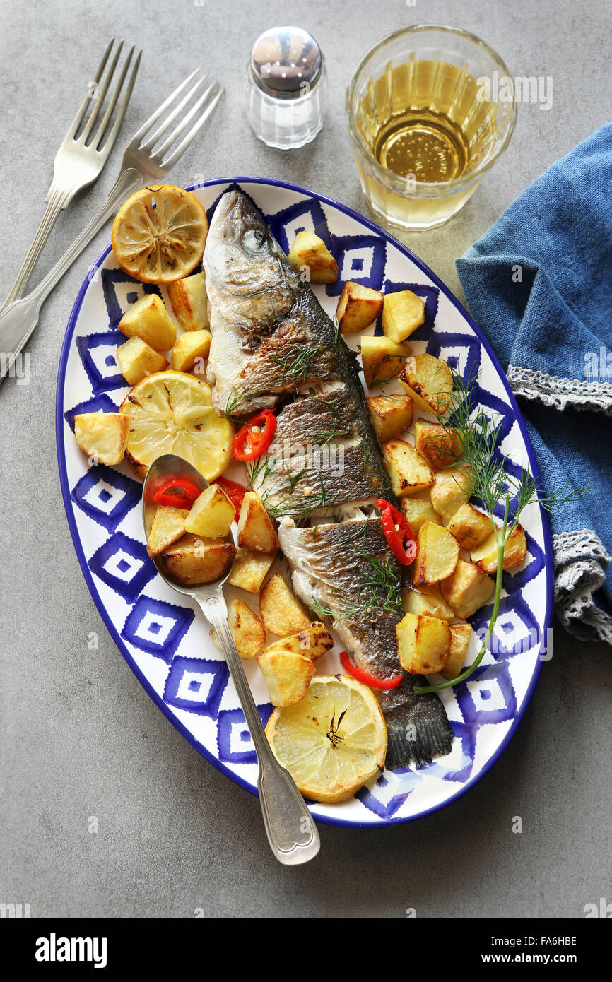 Ovenbaked Sea bass fish with lemon and potatoes Stock Photo Alamy
